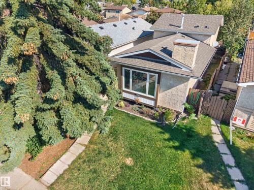 Exterior featuring stucco finish, a prominent chimney, and a shingled roof - 333 Kirkpatrick Crescent Nw, Edmonton, AB 