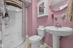 Pedestal sink with chrome fixtures, glass-enclosed shower, white wall-mounted medicine cabinet, wall-mounted mirror, and tile flooring - 
