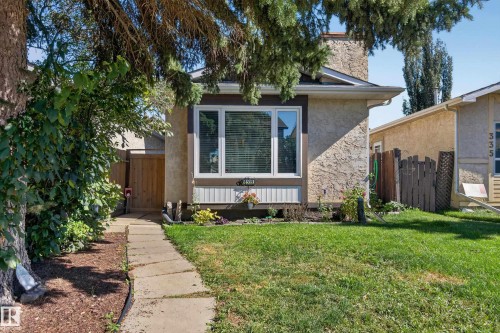 Stucco exterior, stone chimney, front lawn, window box, and a paver walkway - 333 Kirkpatrick Crescent Nw, Edmonton, AB 