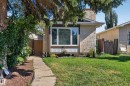 Stucco exterior, stone chimney, front lawn, window box, and a paver walkway - 333 Kirkpatrick Crescent Nw, Edmonton, AB 