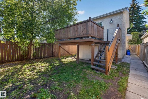 Two-story wood deck with stairs, stucco exterior, privacy fence, and concrete walkway - 333 Kirkpatrick Crescent Nw, Edmonton, AB 