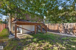 Elevated wood deck with stairs, wood privacy fencing, and a ground-level patio area - 