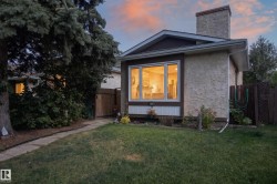 Stucco exterior with a prominent chimney, bay window, and gabled roofline - 