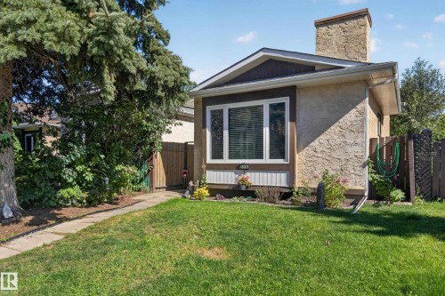 Stucco exterior with a prominent chimney and wood trim accents - 333 Kirkpatrick Crescent Nw, Edmonton, AB 