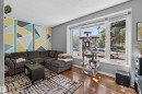 Hardwood-finish flooring, accent wall with geometric pattern, large picture windows, and ceiling-mounted light fixture - 333 Kirkpatrick Crescent Nw, Edmonton, AB 
