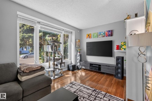 Hardwood flooring, light gray walls, large picture windows, white window blinds, and a built-in media console - 333 Kirkpatrick Crescent Nw, Edmonton, AB 