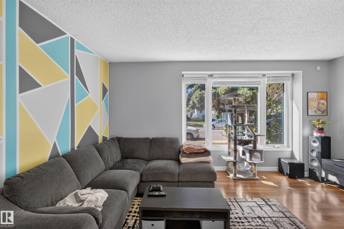 Hardwood-finish flooring with a geometric accent wall - 333 Kirkpatrick Crescent Nw, Edmonton, AB 