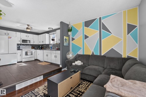 Kitchen with white cabinetry, white appliances, and dark tile flooring - 333 Kirkpatrick Crescent Nw, Edmonton, AB 