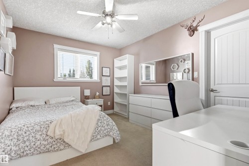 Spacious room featuring a ceiling fan, window with blinds, and light-toned wall paint - 703 107A Street Sw, Edmonton, AB 