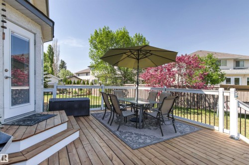 Expansive wood deck with white railings and black balusters - 703 107A Street Sw, Edmonton, AB 