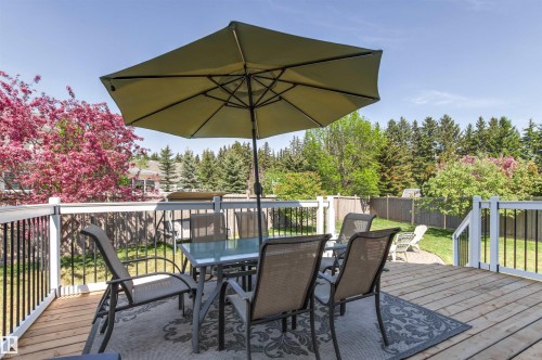 Expansive wood deck with white and black railing, offering exterior space for entertaining - 703 107A Street Sw, Edmonton, AB 