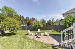 Expansive lawn featuring mature trees and a fenced perimeter - 