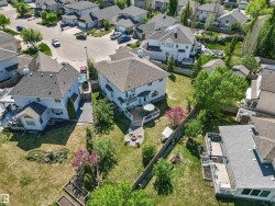 Spacious backyard with a multi-level deck, concrete patio, and mature trees - 