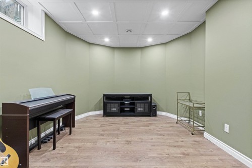 Recessed lighting illuminating wood-finish flooring and light green walls - 703 107A Street Sw, Edmonton, AB 