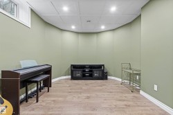 Recessed lighting illuminating wood-finish flooring and light green walls - 