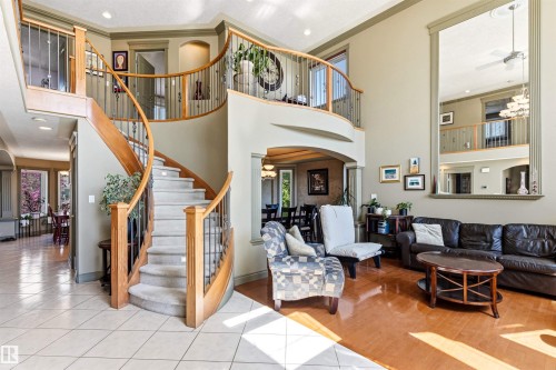 Grand curved staircase with wood banister and wrought iron spindles - 703 107A Street Sw, Edmonton, AB 