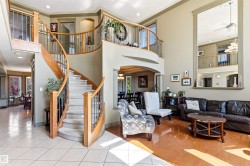 Grand curved staircase with wood banister and wrought iron spindles - 