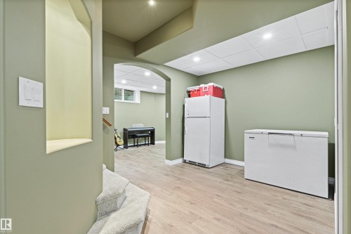 Archway entry to a flexible space with wood-finish flooring - 703 107A Street Sw, Edmonton, AB 