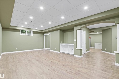 Recessed lighting, wood-finish flooring, built-in shelving, white trim, and a window - 703 107A Street Sw, Edmonton, AB 
