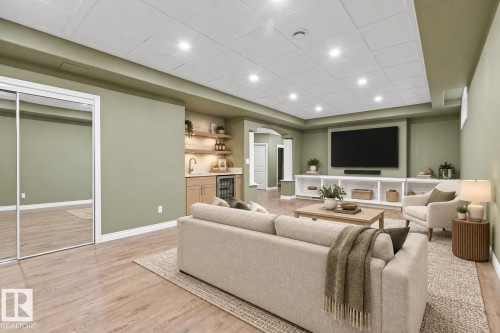 Recessed lighting illuminates the wood-finish flooring - 703 107A Street Sw, Edmonton, AB 