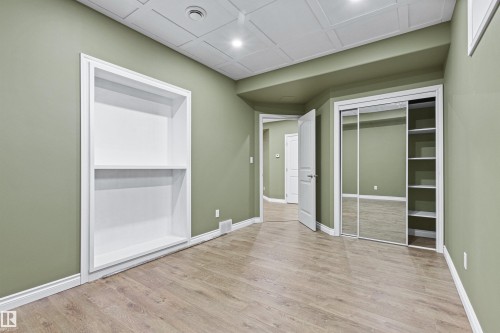 Wood-finish flooring, recessed lighting, built-in shelving, mirrored sliding closet doors, and a paneled ceiling - 703 107A Street Sw, Edmonton, AB 