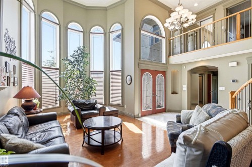 Two-story foyer featuring red double entry doors with decorative glass panels - 703 107A Street Sw, Edmonton, AB 