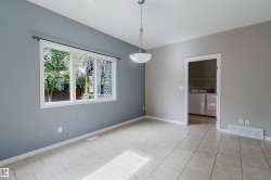 Recessed ceiling light, built-in shelving, tile flooring, window with white frame, and white trim - 
