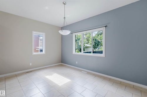 Tile flooring, dual paint tones, white trim windows, and a semi-flush mount light fixture - 11608 96 Street Nw, Edmonton, AB 
