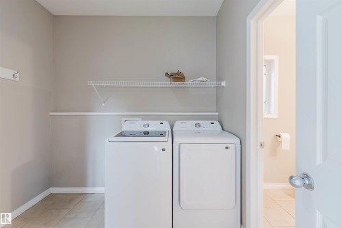 Laundry area with tile flooring and a wall-mounted wire shelf - 11608 96 Street Nw, Edmonton, AB 