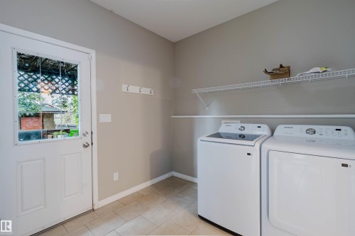 Neutral wall paint, tiled flooring, white wire shelving, wall-mounted coat rack, and a glass-paneled door - 11608 96 Street Nw, Edmonton, AB 