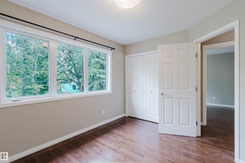 Wood-finish flooring, white trim, and a white six-panel door - 11608 96 Street Nw, Edmonton, AB 