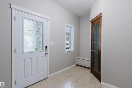 Tiled entry with a white paneled front door, secure keypad entry, and a side window - 11608 96 Street Nw, Edmonton, AB 