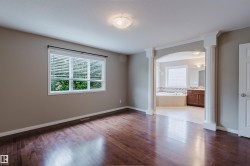Dark wood-finish flooring with an arched entryway leading to an attached bathroom - 