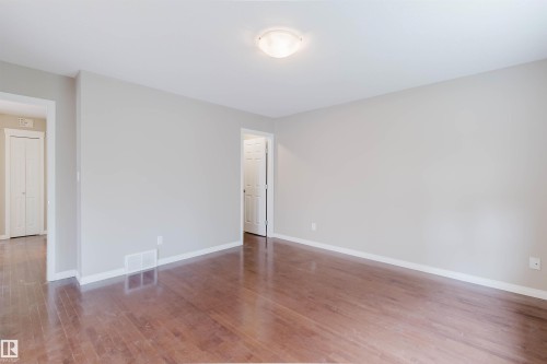Wood-finish flooring, neutral wall tones, white trim, and a ceiling-mounted light fixture - 11608 96 Street Nw, Edmonton, AB 