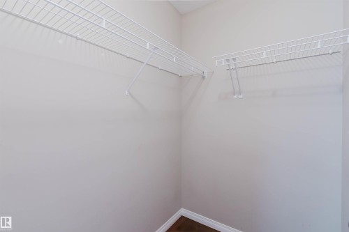 Interior closet featuring wire shelving and dark wood-finish flooring - 11608 96 Street Nw, Edmonton, AB 
