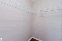 Interior closet featuring wire shelving and dark wood-finish flooring - 