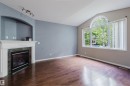 Vaulted ceiling, wood-finish flooring, fireplace with tile surround, arched alcove, and large arched window - 11608 96 Street Nw, Edmonton, AB 