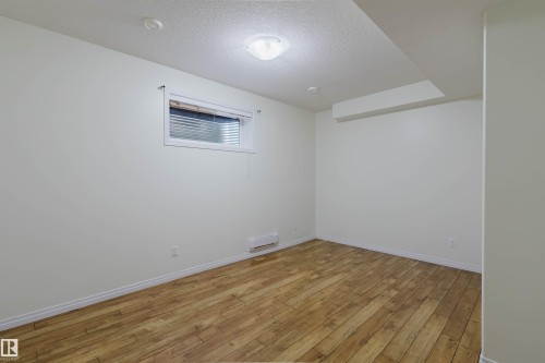 Room featuring wood-finish flooring, recessed lighting, and a ceiling-mounted light fixture - 11608 96 Street Nw, Edmonton, AB 