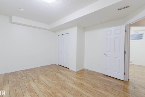 Wood-finish flooring, bi-fold closet doors, and recessed ceiling lighting - 11608 96 Street Nw, Edmonton, AB 