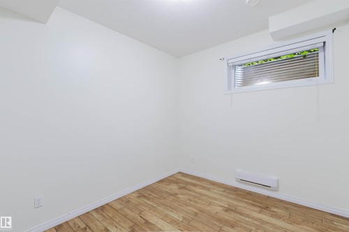 Wood-finish flooring, white painted walls, and a window with blinds - 11608 96 Street Nw, Edmonton, AB 