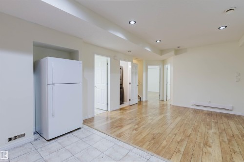 Recessed lighting, wood-finish flooring, white tile flooring, built-in refrigerator, and multiple interior doorways - 11608 96 Street Nw, Edmonton, AB 