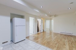 Recessed lighting, wood-finish flooring, white tile flooring, built-in refrigerator, and multiple interior doorways - 