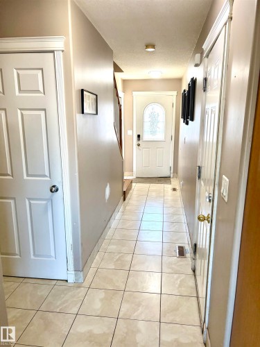Tiled flooring with neutral tones throughout this hallway - #17 16317 64 St Nw, Edmonton, AB 