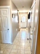 Tiled flooring with neutral tones throughout this hallway - 