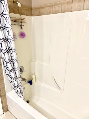 Built-in white acrylic bathtub and shower surround with a grab bar - #17 16317 64 St Nw, Edmonton, AB 