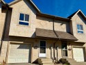 Stucco exterior with decorative accents, individual garage access, and separate entryways - #17 16317 64 St Nw, Edmonton, AB 