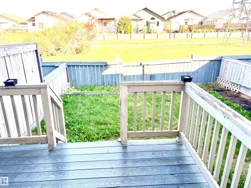Backyard featuring a composite deck, wood railing, and a fenced perimeter - #17 16317 64 St Nw, Edmonton, AB 