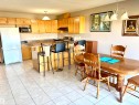Kitchen with light wood cabinetry, a built-in microwave, tiled backsplash, and a breakfast bar - #17 16317 64 St Nw, Edmonton, AB 