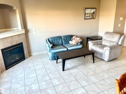 Tiled flooring throughout, fireplace with a tiled surround, and neutral wall tones - 