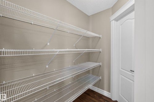 White wire shelving system, neutral wall paint, white trim, and wood-finish flooring - 1850 Rutherford Road Sw, Edmonton, AB 